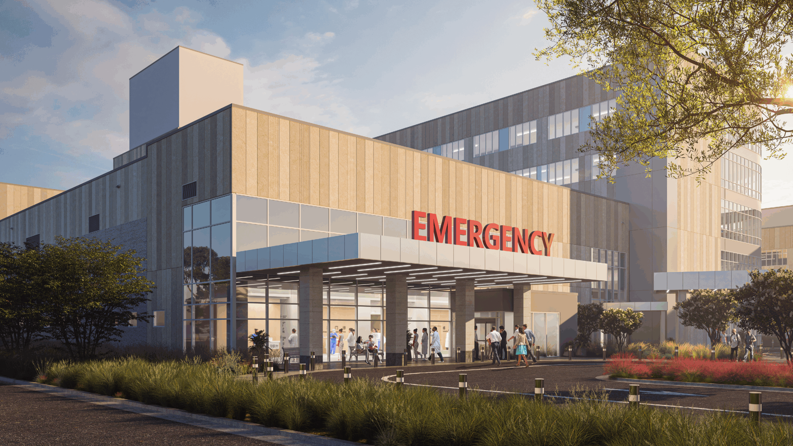 An exterior view of a building from a corner with a huge 'EMERGENCY' sign at the top of the lobby canopy.