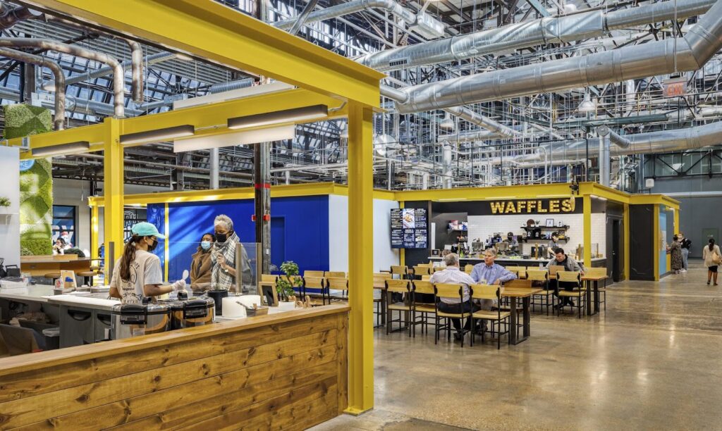 People sitting in the newly created City Foundry STL, a food hall.