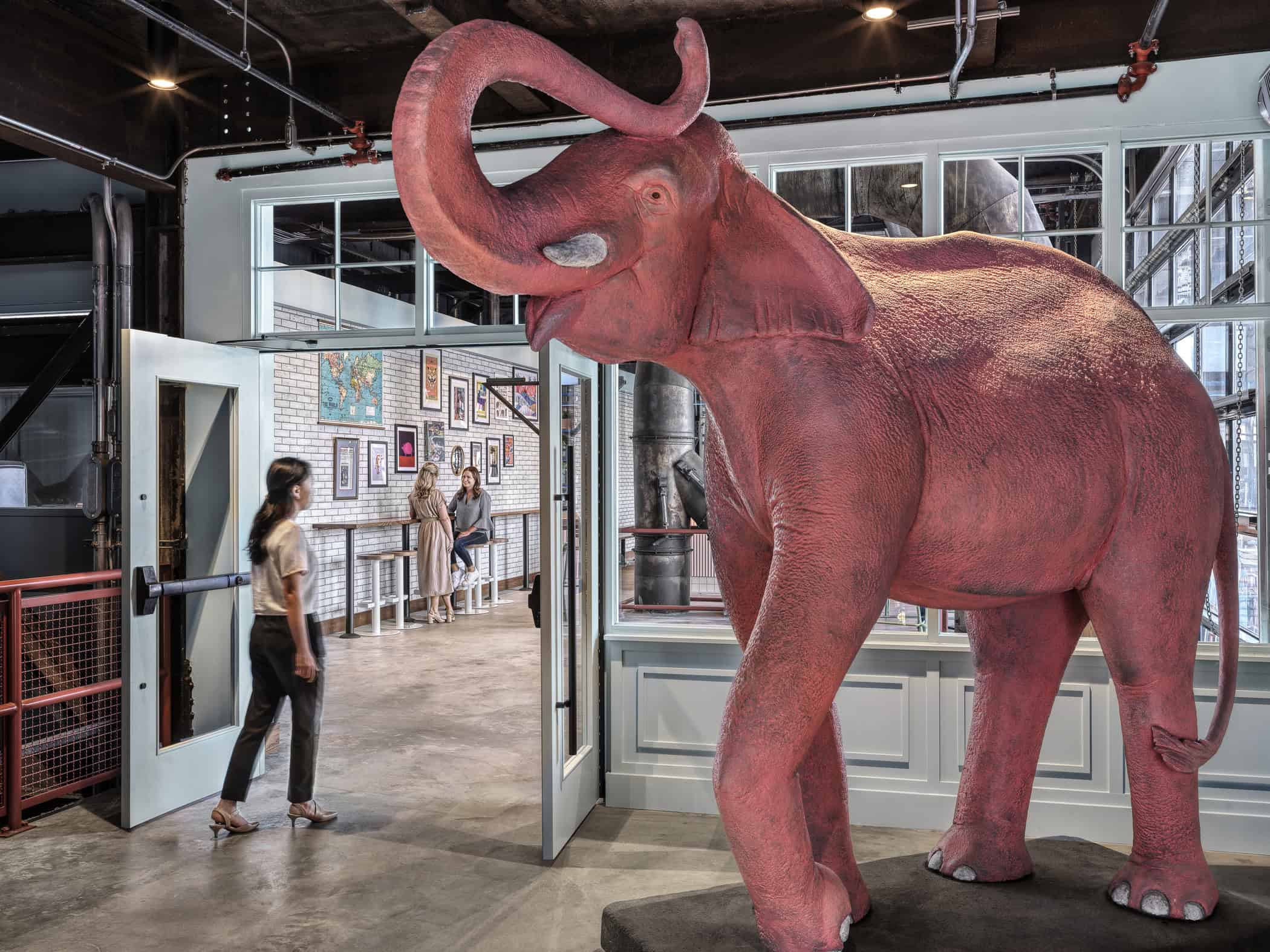 A woman walking into Expat BBQ second floor bar next to a large elephant sculpture