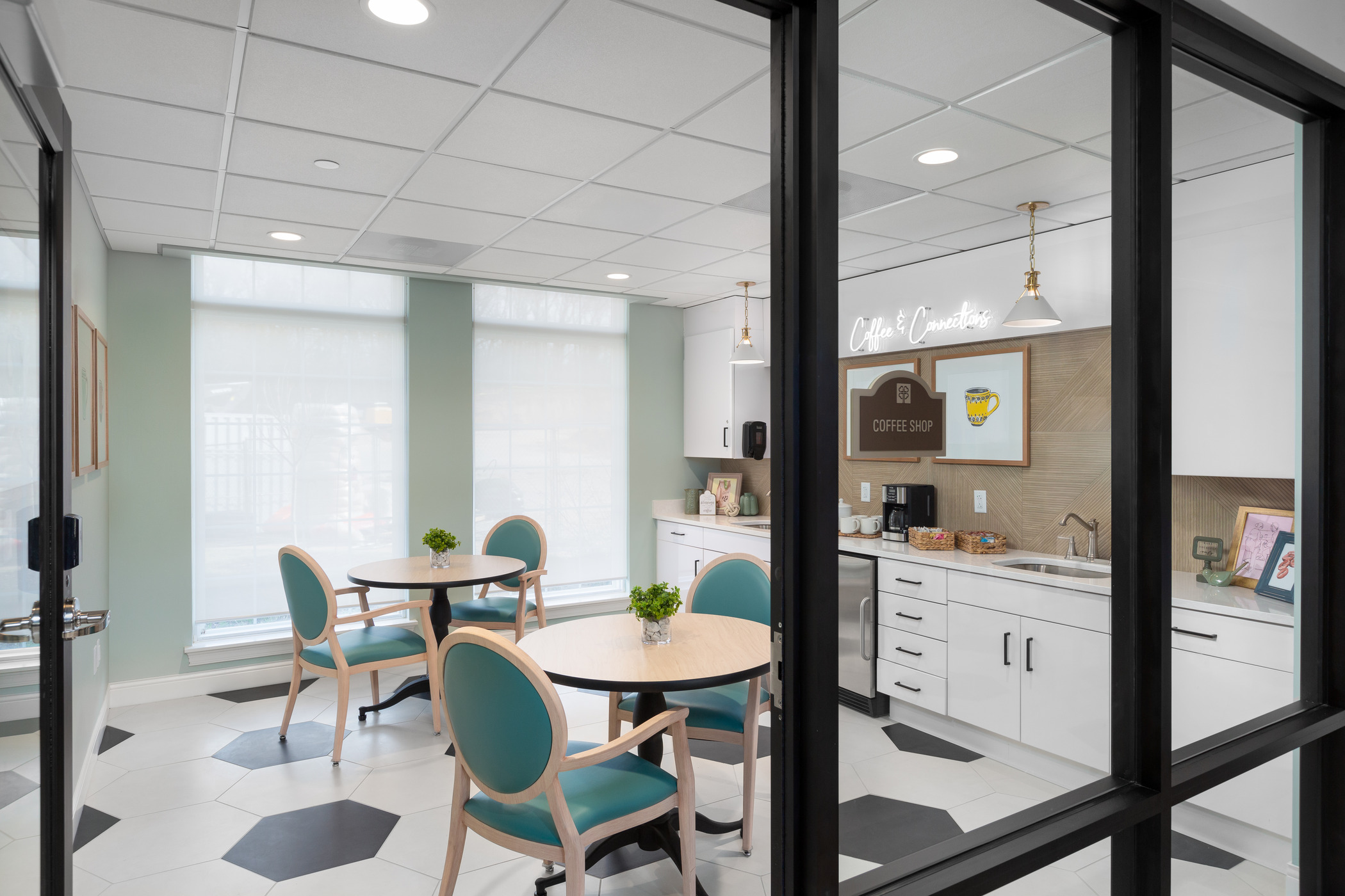 A coffee lounge is photographed through an exterior glass vestibule