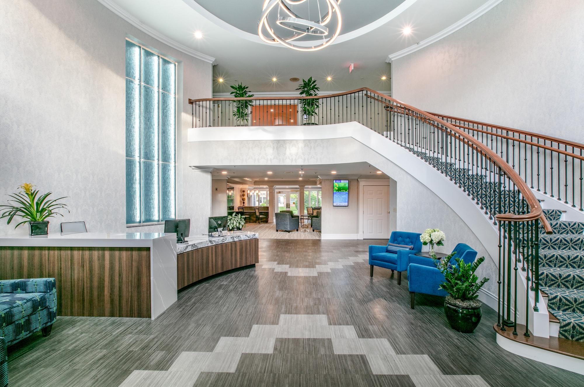 A photograph of the interior of an entrace with a curved staircase going up to a second floor