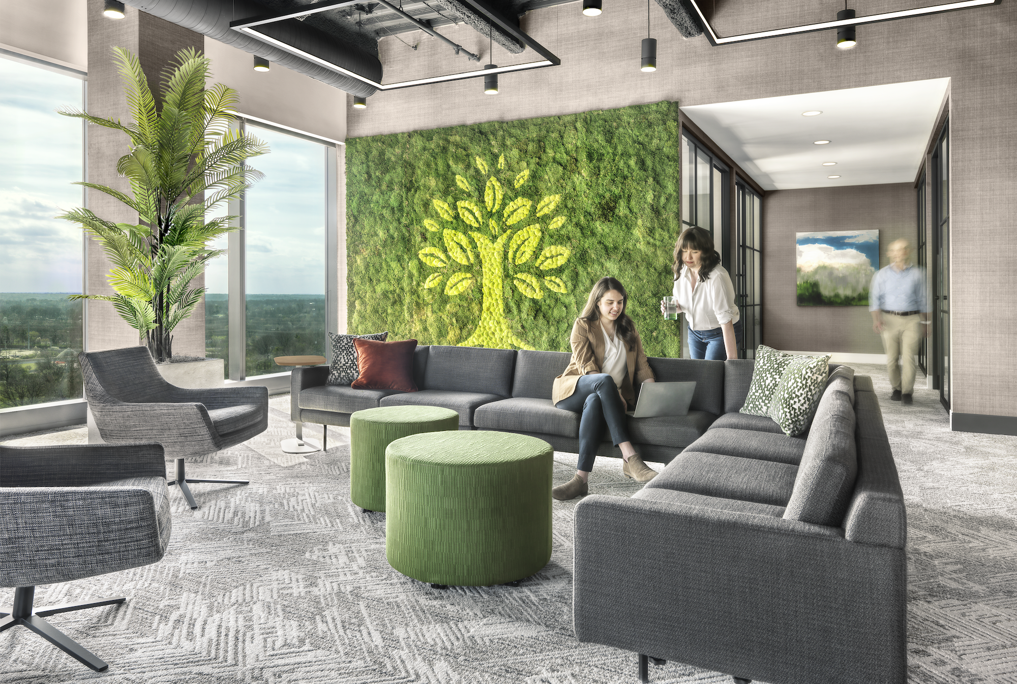 A photograph of an interior with a gray couch, green circular tables, two people, and large artwork with an image of a green tree
