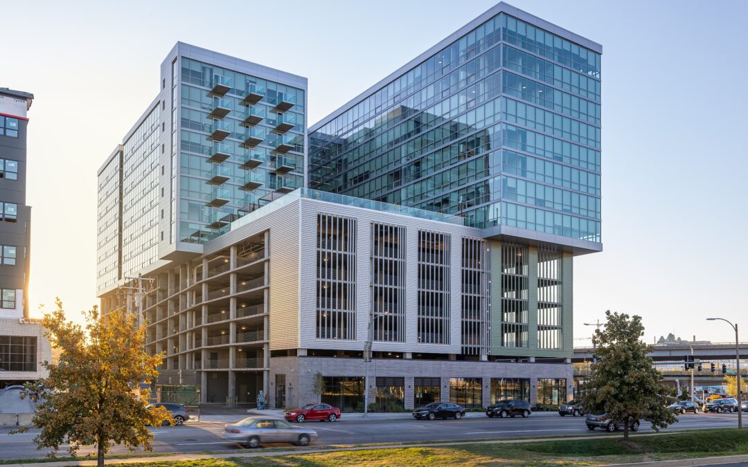 A photograph of the exterior of a modern building made up of rectangles of different materials including glass, concrete, and metal