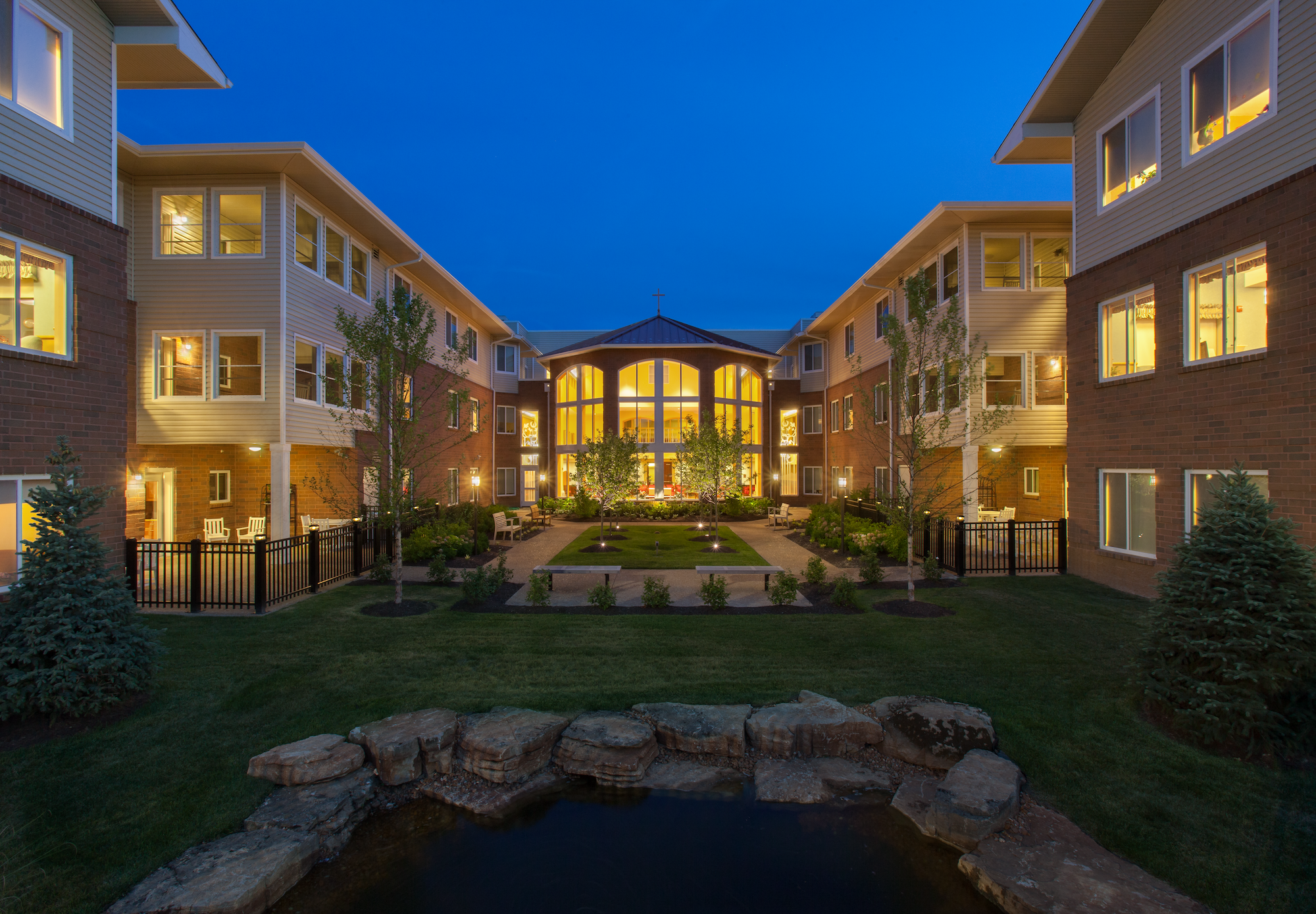 A photograph from the couryard facing toward the outside of a building in the evening.