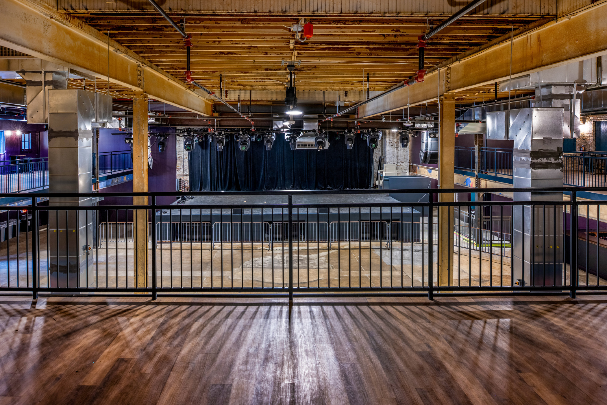 View from mezzanine at The Sovereign concert venue in St. Louis showing stage, metal railing, and exposed beams.