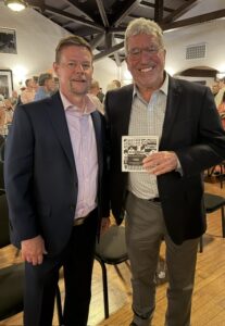 A photo of Mike Schnaare (left) and Steve Smith (right) holding the Most Enhanced Award placard. 